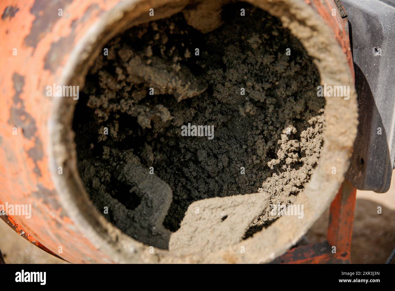 Béton dans un malaxeur orange sur le chantier de construction Banque D'Images