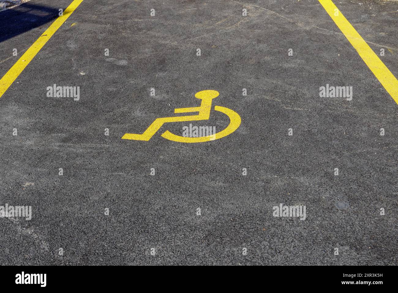 Panneau pour handicapés sur la route asphaltée dans le parking Banque D'Images