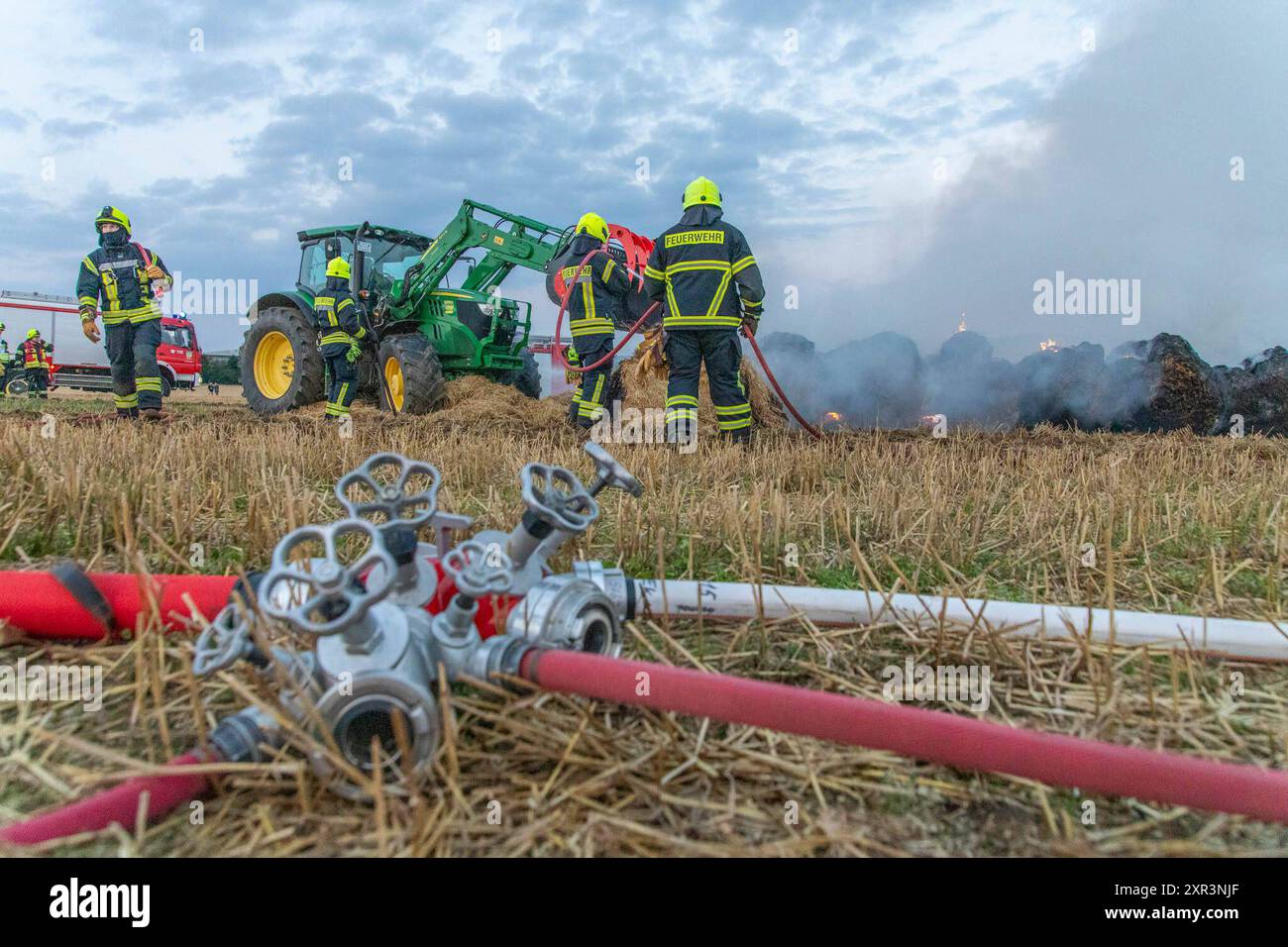 240808Strohballenbrand News ID : en 2024-08-08 Strohballenbrand beschäftigt Einsatzkräfte Landwirte unterstützen Brandbekämpfung Gornau. AM Donnerstagabend gegen 19:50 Uhr ist auf einem Feld an der Eisenstraße ein Strohballenbrand ausgebrochen. Wie die Feuerwehr berichtet, standen BEI Ankunft der ersten Kräfte, 30 Strohballen in Vollbrand. Umgehend begann man mit der Brandbekämpfung. Zeitgleich verhinderten die Kameraden eine weitere Ausbreitung des Brandes. unterstützt wurden die Löschmaßnahmen von Landwirten. Diese pflügten das Stoppelfeld um und nahmen SO dem Feuer das brennbare matériel. Au Banque D'Images