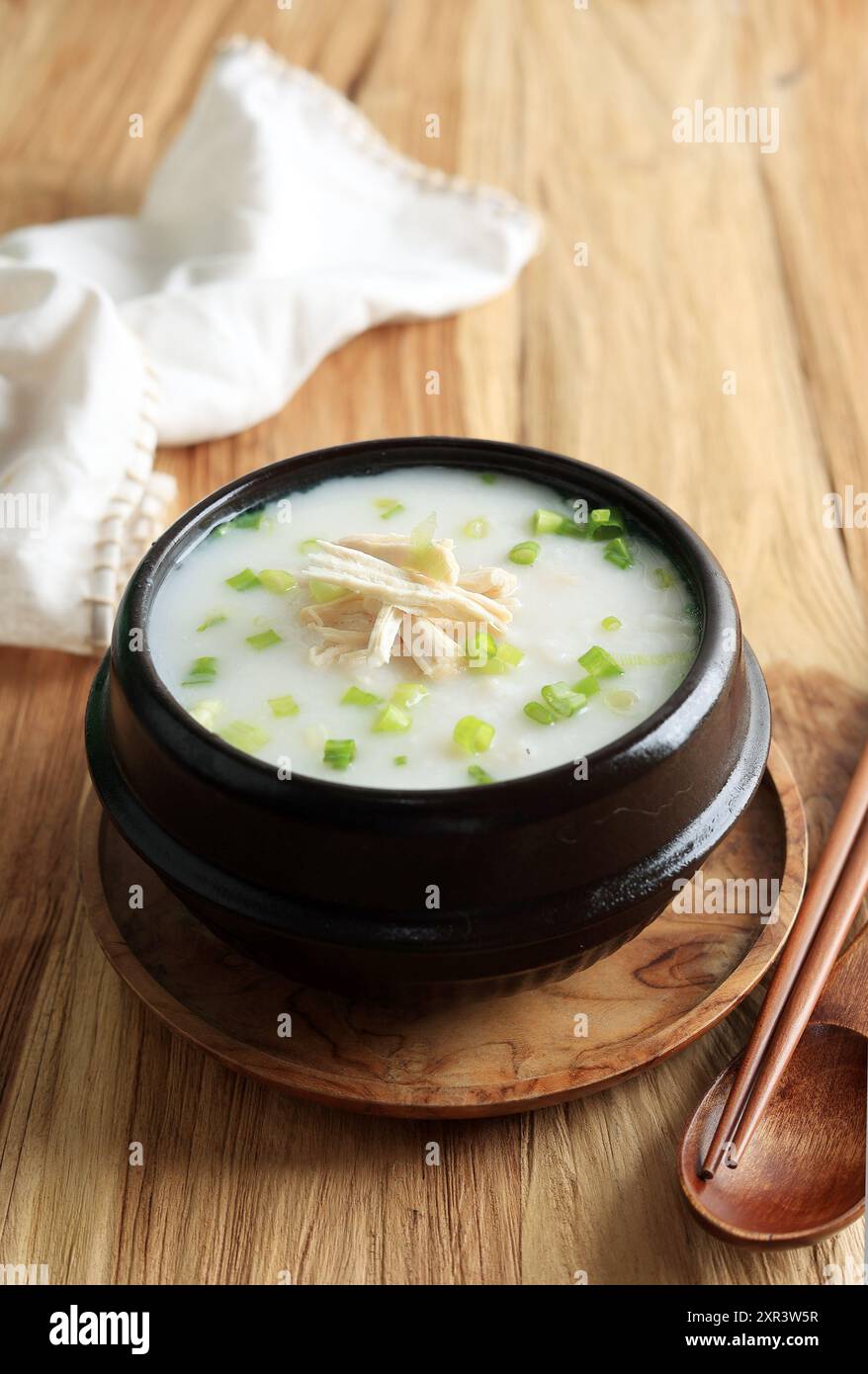 Dakjuk, bouillie de poulet au riz coréen avec oignon vert haché. Servi sur Ttukbaegi, Korean Stone Bowl Banque D'Images