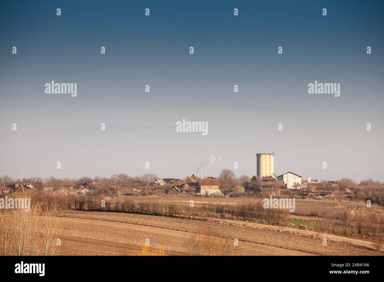 Cette vue panoramique capture un petit village de Voïvodine, en Serbie, sur fond de vastes champs agricoles. La scène reflète le rur Banque D'Images Cette vue panoramique capture un petit village de Voïvodine, en Serbie, sur fond de vastes champs agricoles. La scène reflète le rur Banque D'Images
