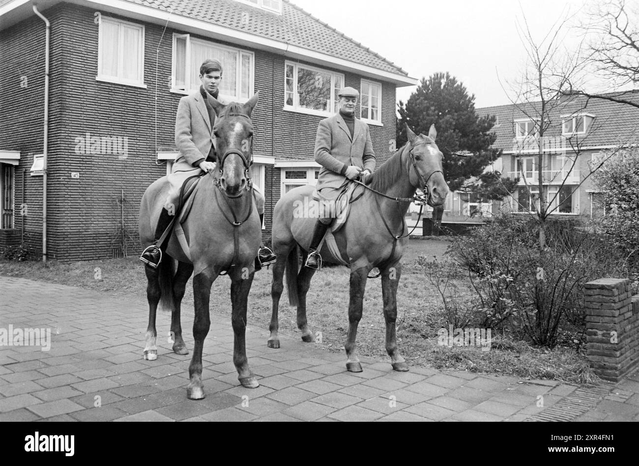 Deux cavaliers à cheval dans une zone résidentielle, Whizgle Dutch News : images historiques sur mesure pour l'avenir. Explorez le passé néerlandais avec des perspectives modernes grâce à des images d'agences néerlandaises. Concilier les événements d'hier avec les perspectives de demain. Embarquez pour un voyage intemporel avec des histoires qui façonnent notre avenir. Banque D'Images