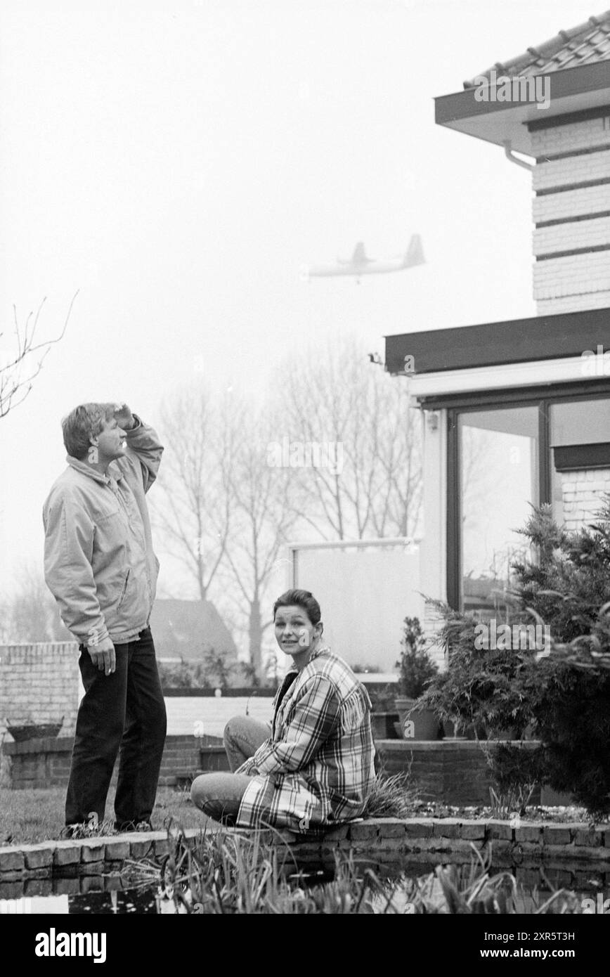 Le couple Van der Schaaf dans leur jardin devant leur maison de Lijnden avec un avion survolant Low, Lijnden, 07-01-1994, Whizgle Dutch News : des images historiques sur mesure pour l'avenir. Explorez le passé néerlandais avec des perspectives modernes grâce à des images d'agences néerlandaises. Concilier les événements d'hier avec les perspectives de demain. Embarquez pour un voyage intemporel avec des histoires qui façonnent notre avenir. Banque D'Images