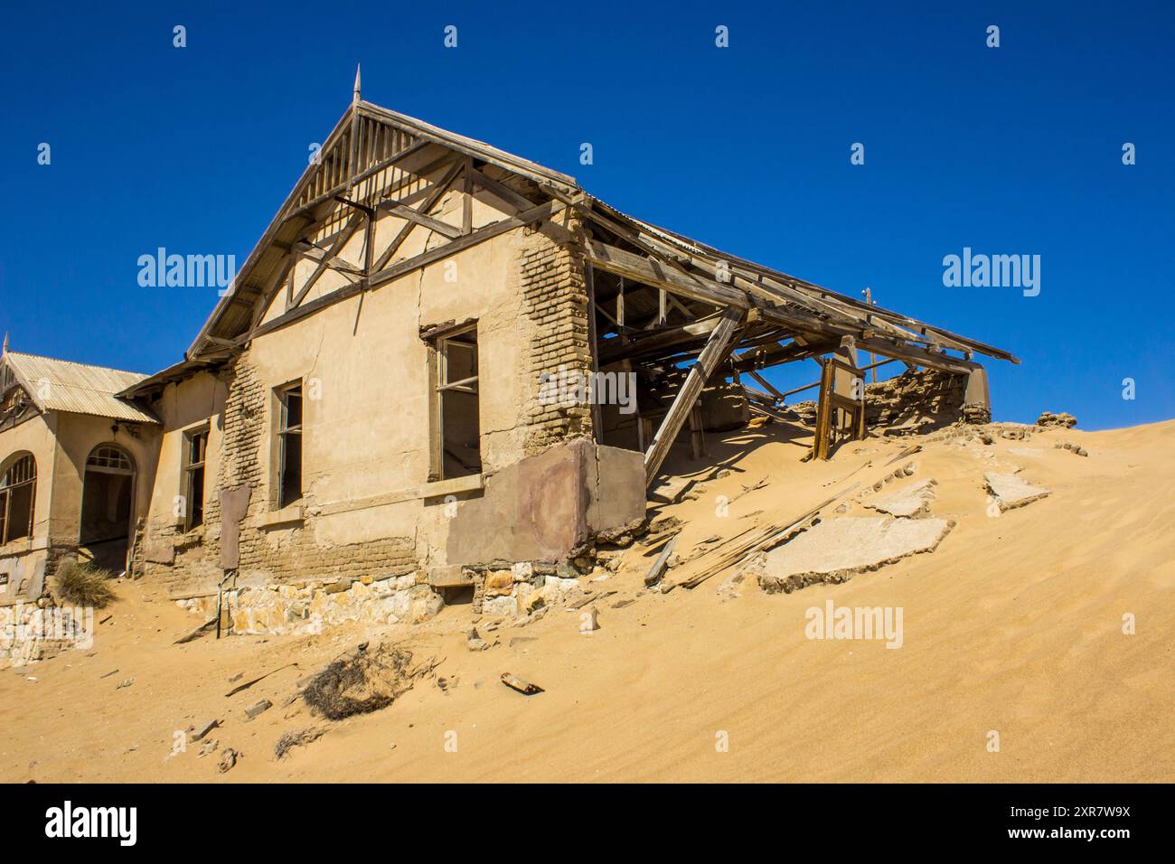 L'ancienne maison des maîtres d'école, enterrée par une dune de sable, dans la ville abandonnée des mines de diamants de Kolmanskuppe. Banque D'Images
