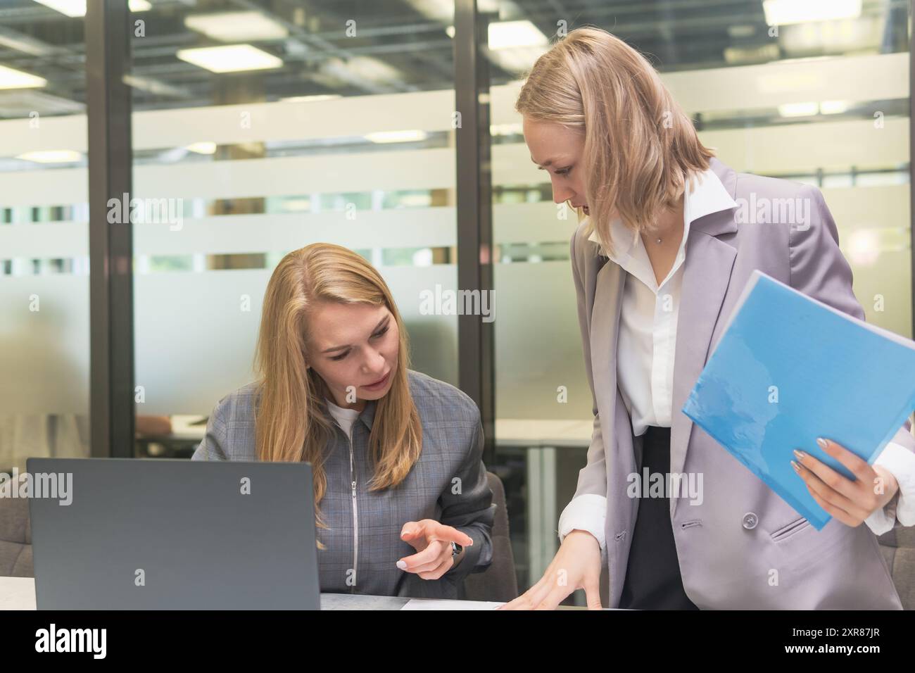 Deux jeunes femmes d'affaires travaillant avec un ordinateur portable et des documents dans l'espace de travail. Banque D'Images