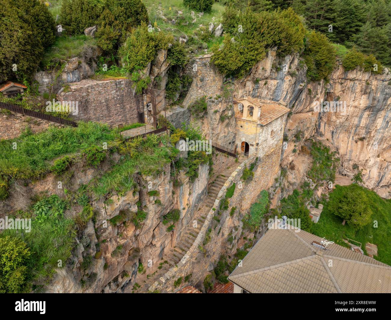 Vue aérienne de l'église Santa Maria de Montgrony, encastrée dans le rocher et les falaises de la chaîne de Montgrony (Ripollès, Gérone, Catalogne Espagne) Banque D'Images