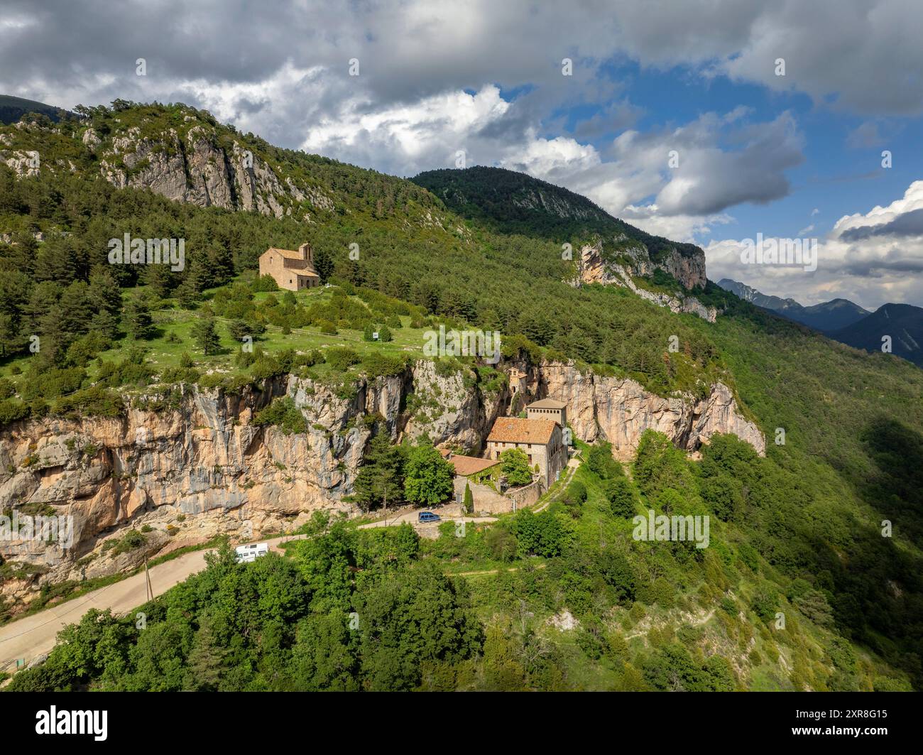 Vue aérienne du sanctuaire de Montgrony construit au pied d'une falaise dans la chaîne montagneuse de Montgrony (Ripollès, Gérone, Catalogne, Espagne, Pyrénées) Banque D'Images