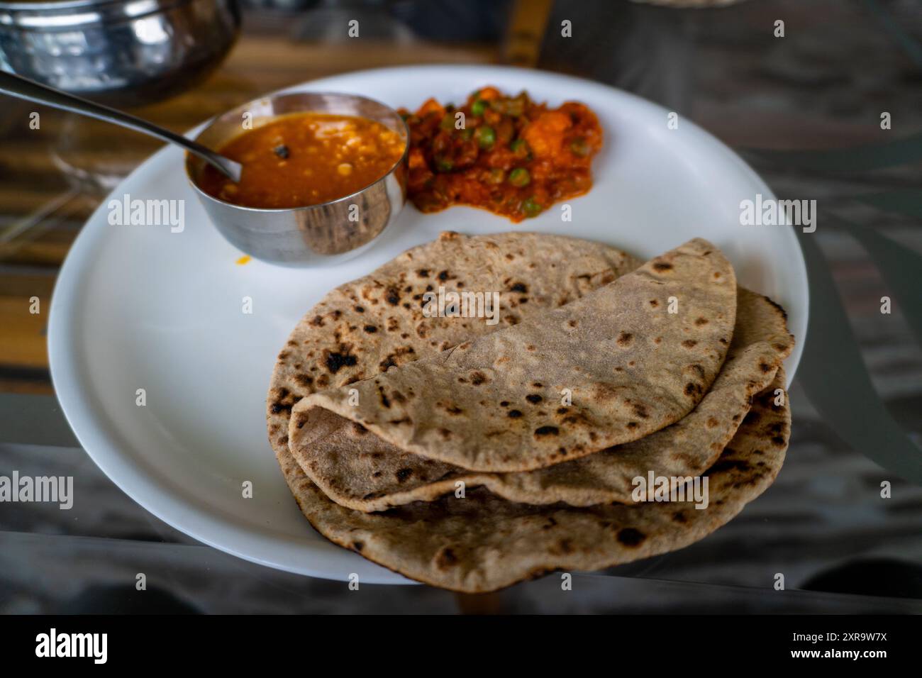 Plateau indien du Nord avec roti, dal et légumes mélangés servis sur une table à manger. Repas sain, apprécié sur la route pendant le voyage dans Himachal P. Banque D'Images