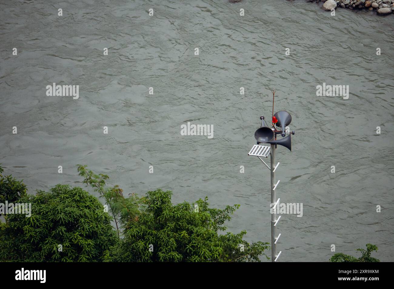 Une sirène d'urgence et une tour d'annonce avec des haut-parleurs situés près d'un canal de barrage dans l'Himachal Pradesh, en Inde, pour les annonces de sécurité pendant les salutations Banque D'Images