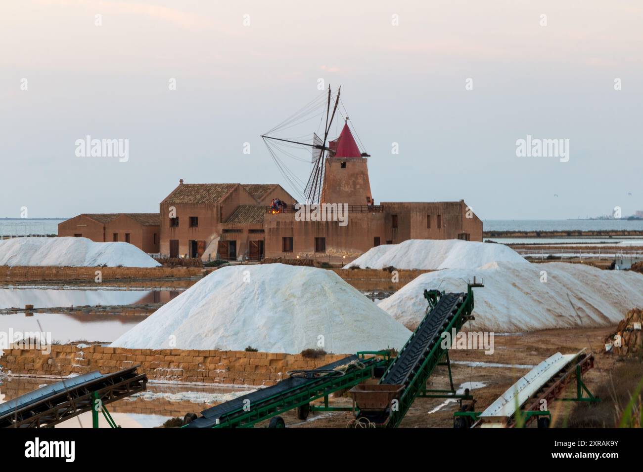 Moulin à vent et tas de sel blanc dans les célèbres mines de sel de Marsala. Banque D'Images