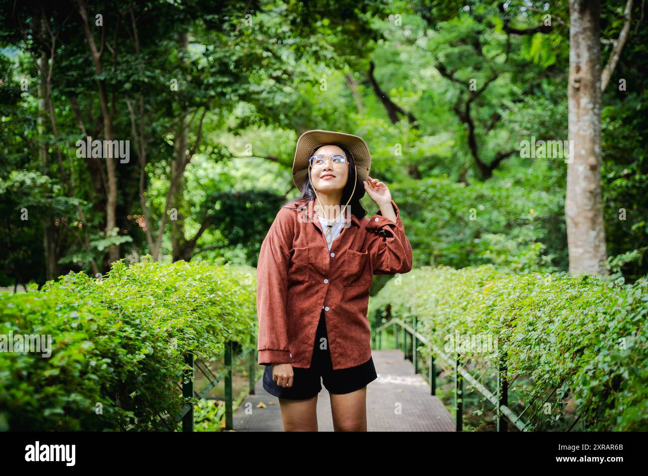 Asiatique jeune belle femme Backpacker voyageant seul dans la forêt sauvage. Attrayant voyageur de fille regarder autour et explorer tout en marchant dans l'esprit de bois de la nature Banque D'Images