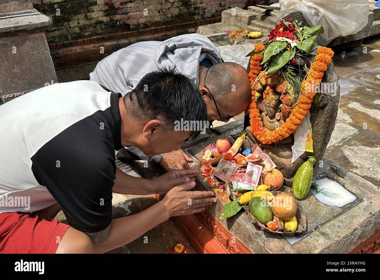 9 août 2024 : les dévots offrent des prières à l'idole de Vasuki Nagraja pour célébrer le Nag-Panchami, un festival hindou pour adorer la divinité serpente à Sankar Kirti Mahabihar, Bhagwan Bahal de Naxal à Katmandou, Népal, le 9 août 2024. L'idole en pierre du Xe siècle de Vasuki Nagraja, volée il y a environ 40 ans, a été restaurée dans son lieu d'origine après la remise du Musée national le 5 août. L'idole a été retournée au Népal par une société privée, Marilynn B. Alsdorf Trust, USA le 24 mai 2022. Crédit : ZUMA Press, Inc/Alamy Live News Banque D'Images