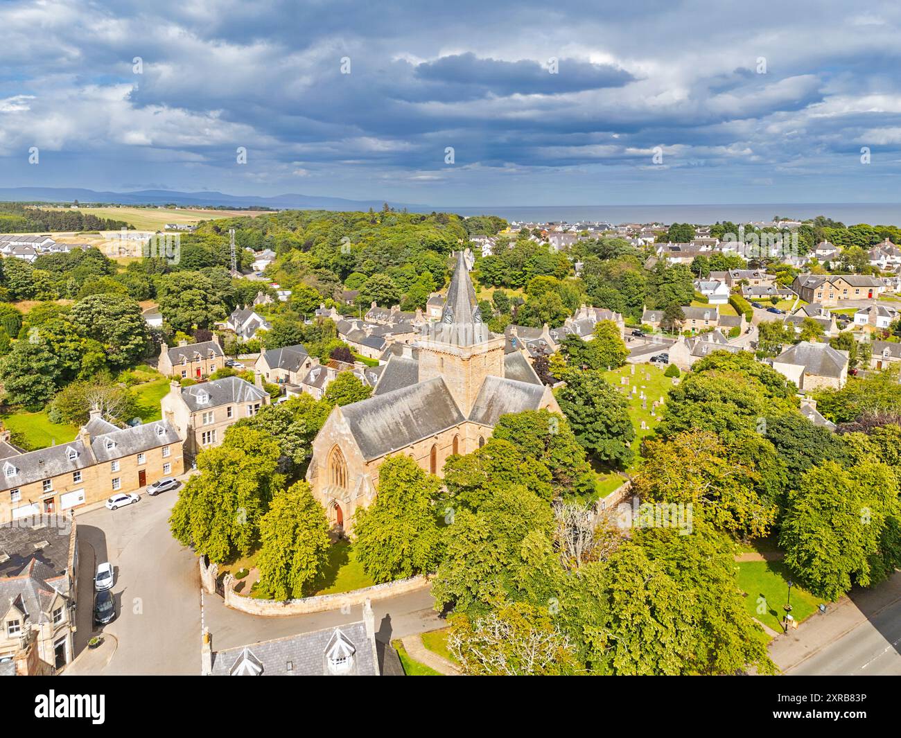 Dornoch Sutherland Écosse la cathédrale et les arbres le cimetière et les maisons de ville en été Banque D'Images