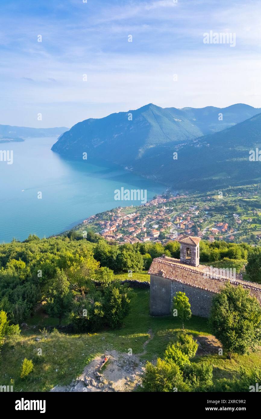 Vue aérienne de la petite église de San Defendente dominant le lac d'Iseo en été, Solto Collina, lac d'Iseo, quartier de Bergame, Lombardie, Italie, Banque D'Images