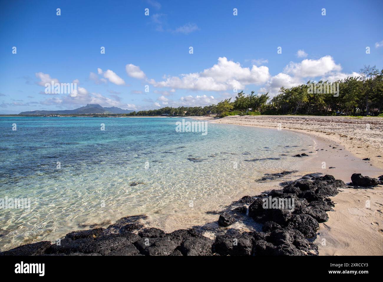 Fantastique plage de sable le matin, île dans l'océan Indien, photo de paysage ou paysage marin avec le soleil se levant sur la mer, petits rochers de lave sur la plage de trou d'eau douce, Maurice Banque D'Images