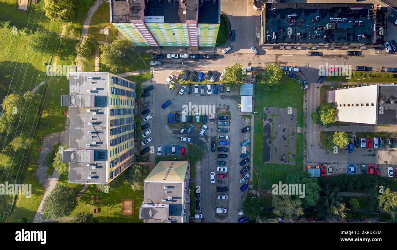 Vue aérienne d'un parking occupé entouré de bâtiments résidentiels et de verdure dans une ville pendant la lumière du jour Banque D'Images