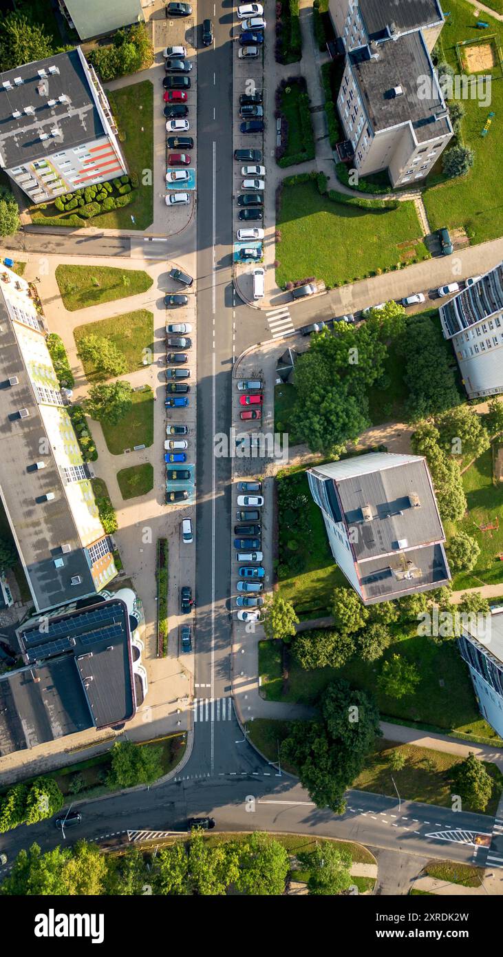 Vue aérienne d'une rue urbaine animée avec des voitures garées et des espaces verts pendant la journée Banque D'Images