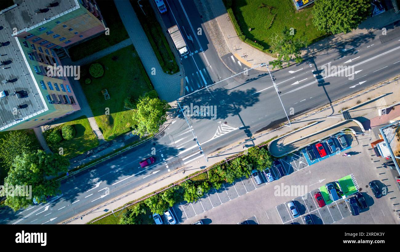 Vue aérienne d'une intersection fréquentée près d'immeubles résidentiels et d'un parking dans une zone urbaine animée pendant la journée Banque D'Images