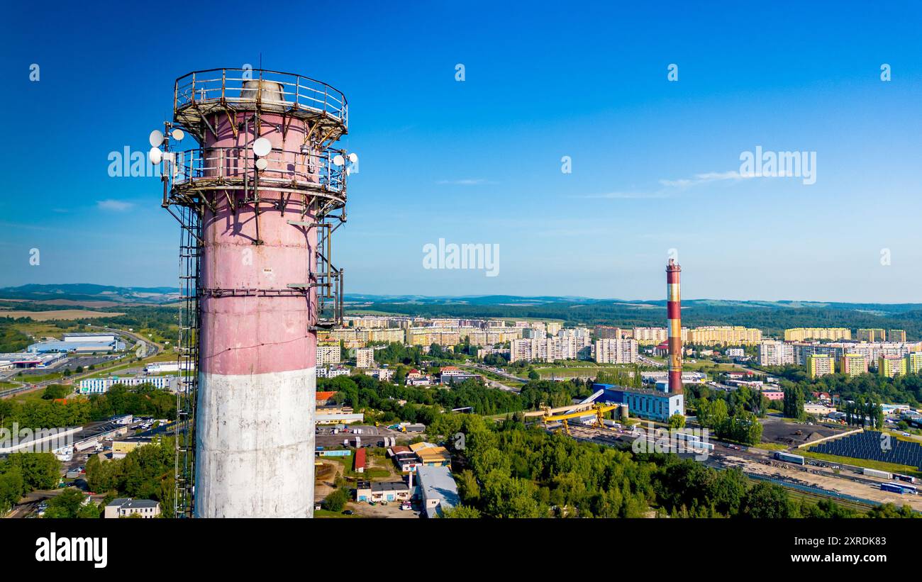 Vue aérienne des cheminées industrielles avec antennes 5g et paysage urbain sous un ciel bleu clair Banque D'Images