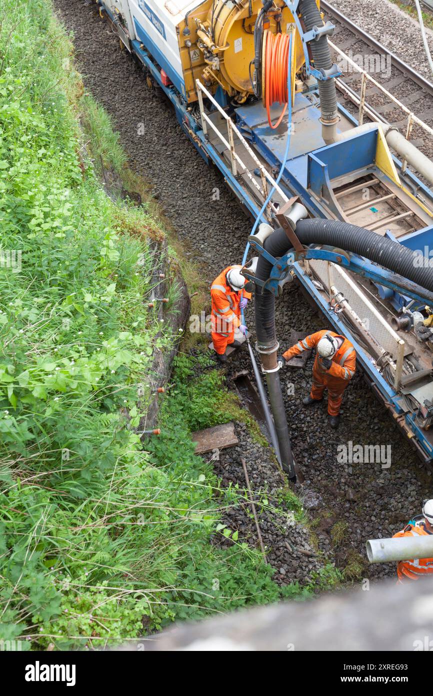 Le train de drainage Balfour Beatty est utilisé pour projeter les drains afin de débloquer les drains sur la ligne principale de la côte ouest en Cumbria Banque D'Images