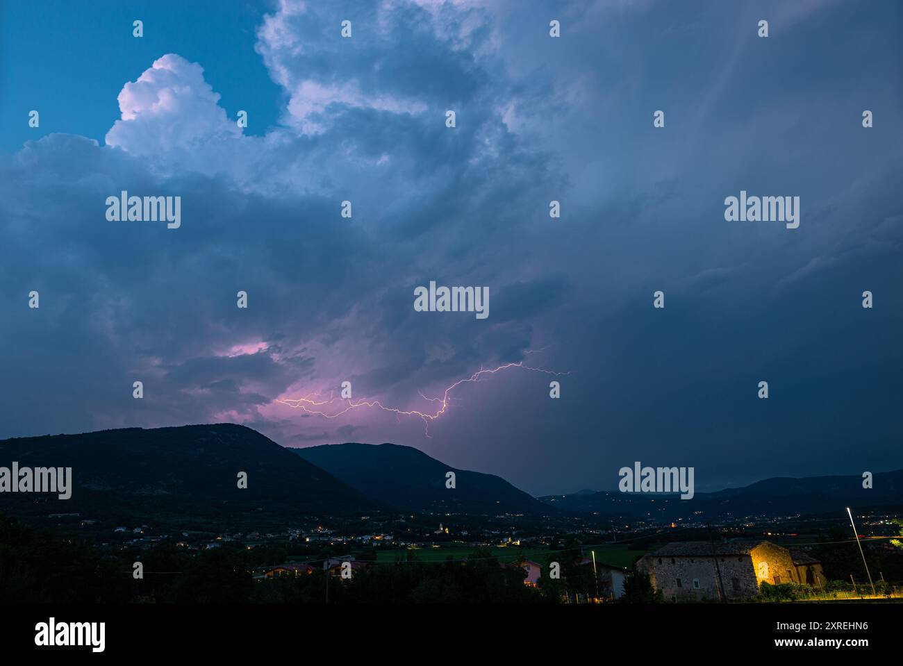 Énorme nuage d'orage avec la foudre rose au-dessus des Alpes italiennes, à l'est du lac de Garde, Italie Banque D'Images