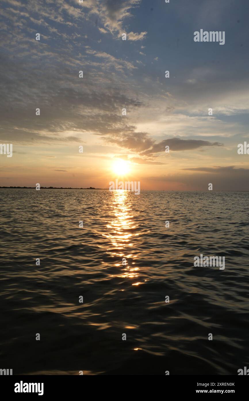 Coucher de soleil doré se reflétant sur la mer Noire près de Sulina, Roumanie Banque D'Images