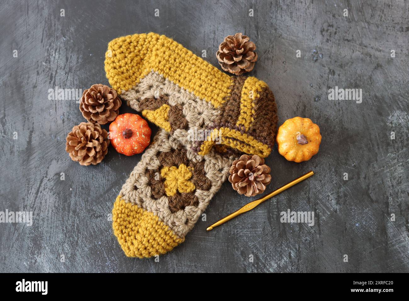 Traverses crochetées sur fond gris foncé avec espace pour le texte. Chaussons de bébé tricotés à la main en laine. Concept de passe-temps d'automne. Banque D'Images