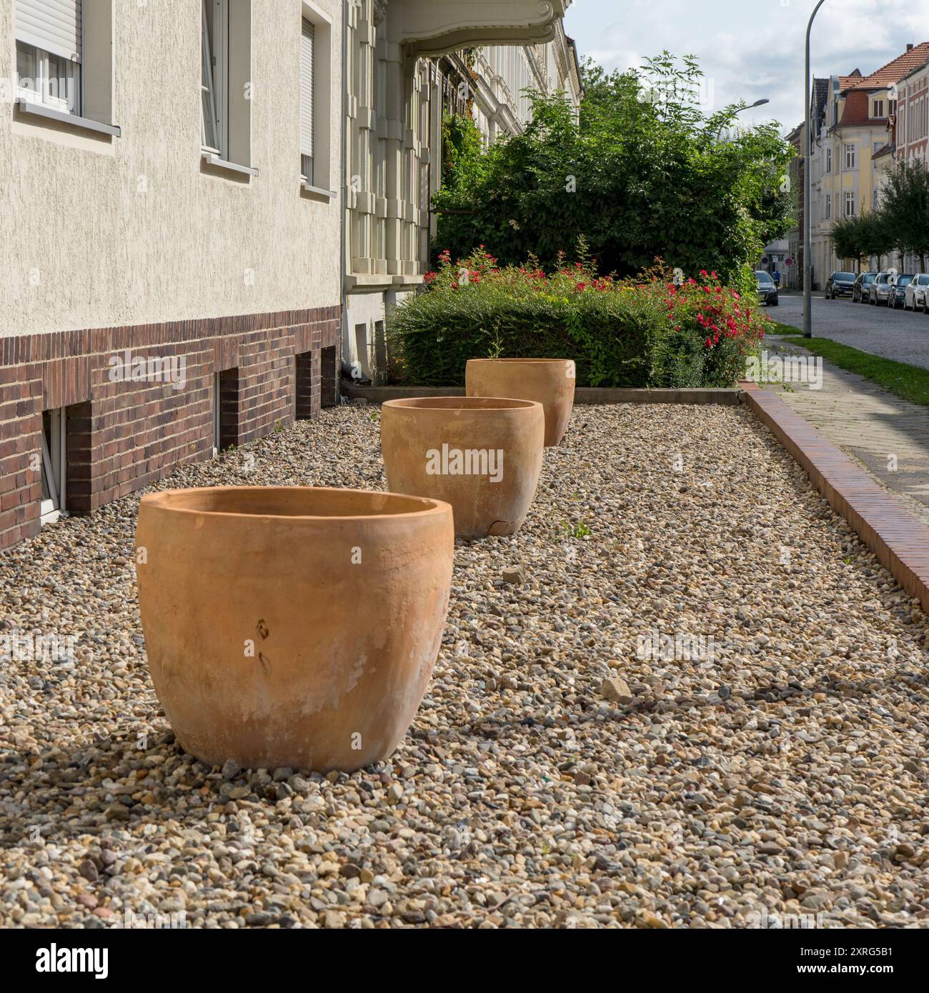 Jardin avant sans plantes avec des cailloux et des pots en terre cuite vides en été Banque D'Images