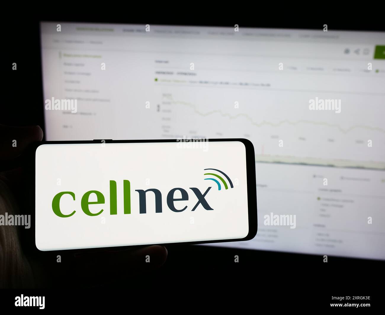 Personne tenant le téléphone portable avec le logo de la société espagnole de télécommunications Cellnex Telecom S.A. en face de la page Web. Concentrez-vous sur l'affichage du téléphone. Banque D'Images