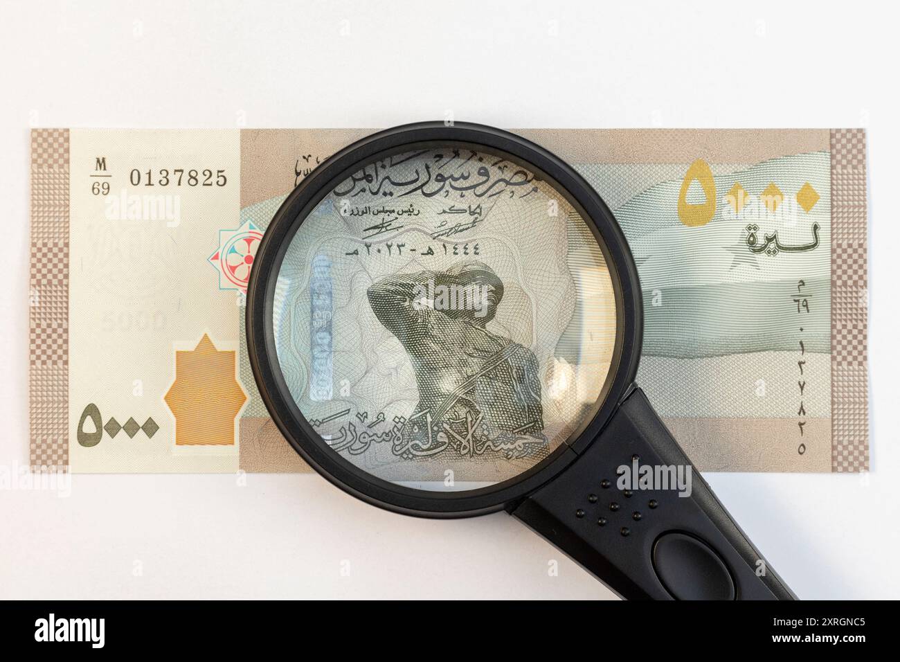 Loupe focalisée sur le soldat sur 5000 billets de banque syriens isolés sur fond blanc Banque D'Images