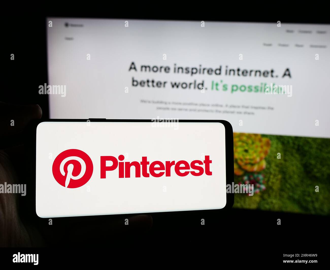 Personne tenant un smartphone avec le logo de la société de médias sociaux américaine Pinterest Inc en face du site Web. Concentrez-vous sur l'affichage du téléphone. Banque D'Images