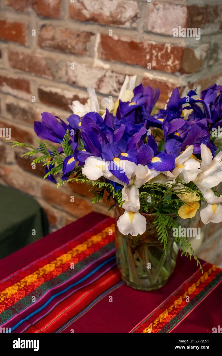 Issaquah, Washington, États-Unis. Bouquet de fleurs d'iris assis sur une table contre un mur de briques rouges. Banque D'Images