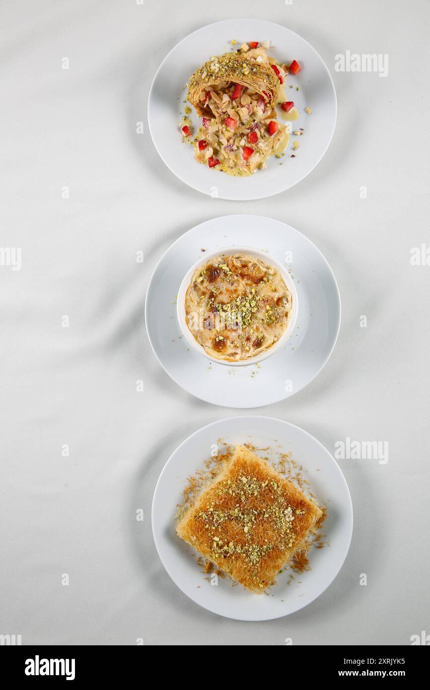 Bonbons traditionnels arabes (kunafa, othmaliye, umm ali) sur fond blanc. vue de dessus, espace de copie Banque D'Images