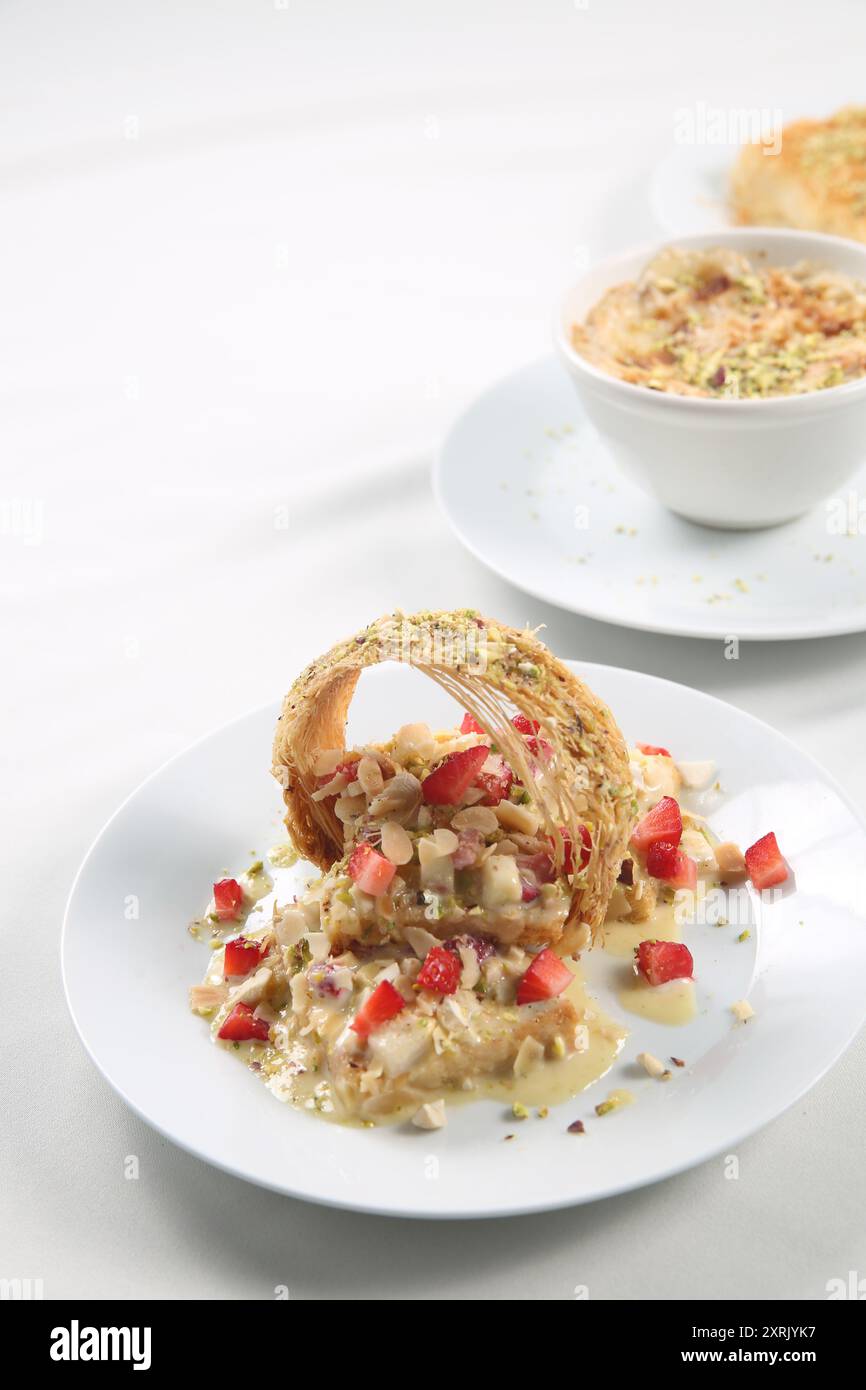 Othmaliye Bil-Kishta et recette de fraise. Populaire arabe Sweet Othmaliye Bil - Kishta - Crunchy Outside with Cream Filling - de la famille Kunafa Banque D'Images