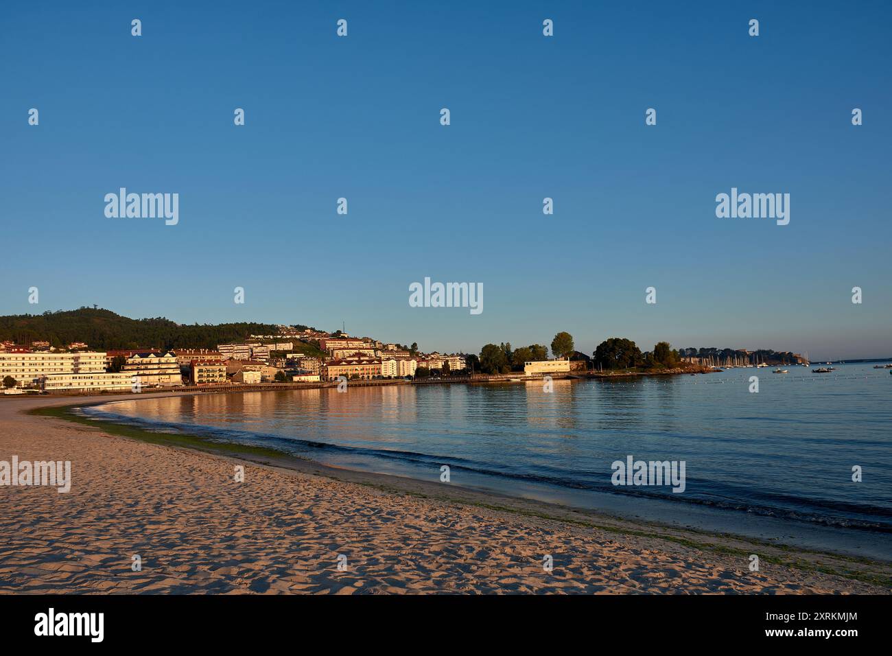 La beauté à couper le souffle de Playa de la Ladeira à Baiona à l'aube. Comme le soleil se lève, sa lumière dorée baigne la plage de sable et les eaux calmes, créant Banque D'Images