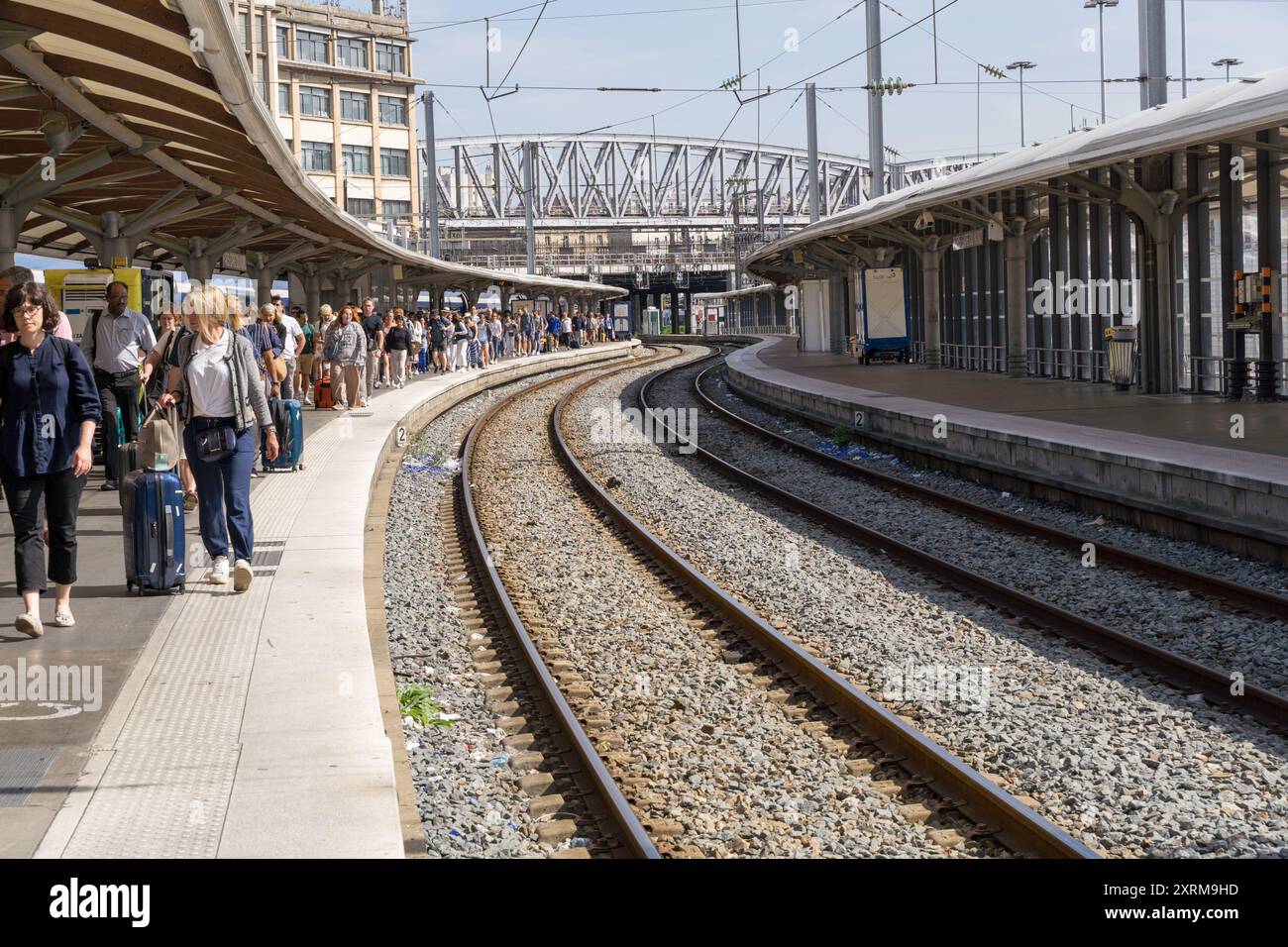 Les passagers descendent à la gare TGV de la Gare du Nord, marchant sur le quai, avec deux voies ferrées vides. Paris France Banque D'Images