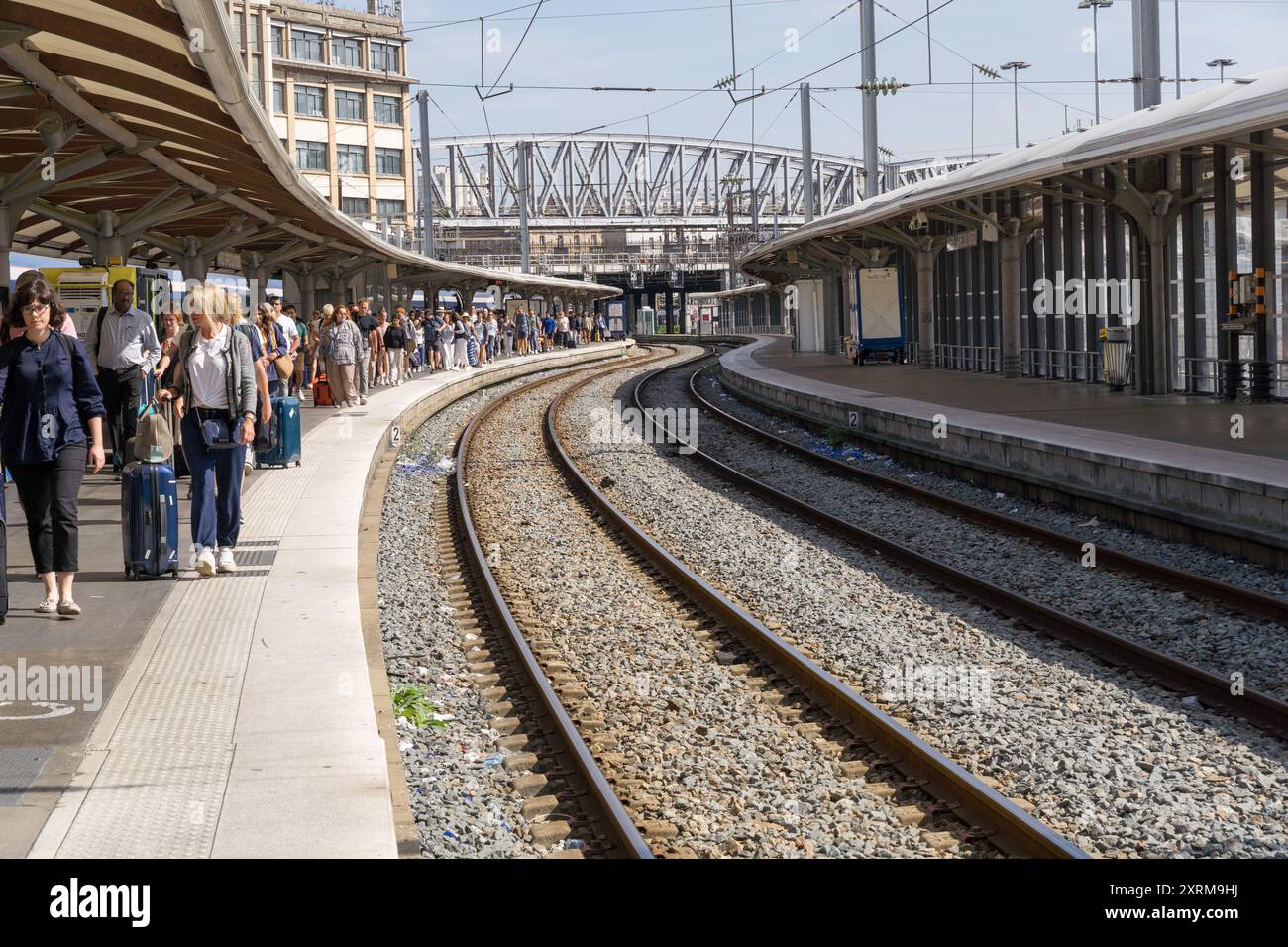 Les passagers descendent à la gare TGV de la Gare du Nord, marchant sur le quai, avec deux voies ferrées vides. Paris France Banque D'Images