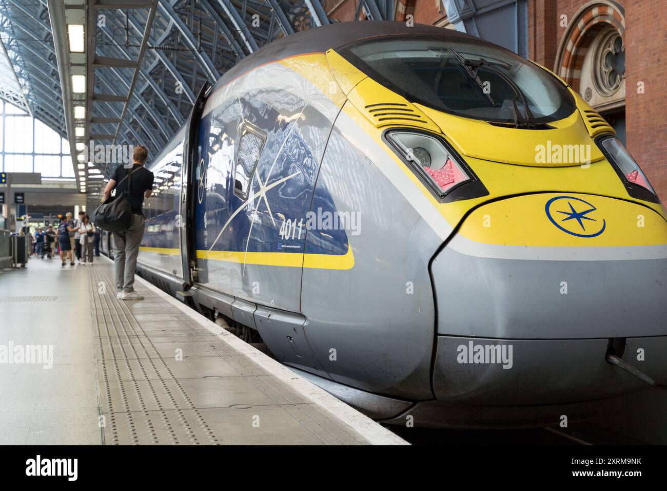 Vue sur le train Eurostar et un passager transporte un sac sur le point de monter à bord du train Eurostar à la gare internationale de St Pancras, Londres, Royaume-Uni Banque D'Images