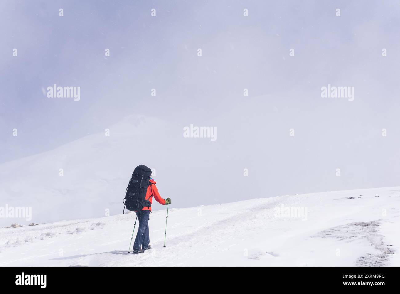 alpiniste grimpe un sommet de montagne enneigé Banque D'Images