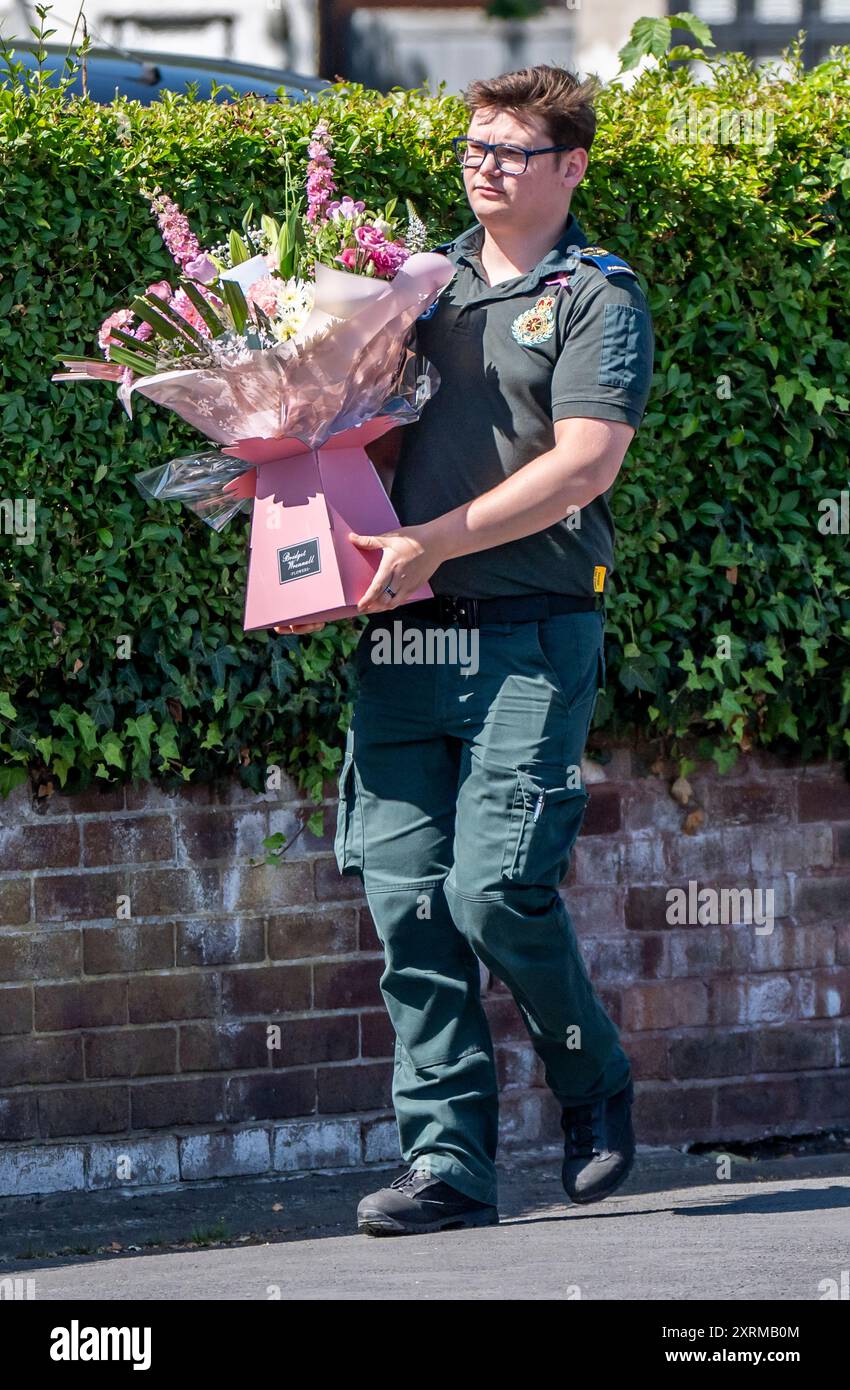 Un ambulancier porte des fleurs, avant les funérailles de Southport poignardant Alice da Silva Aguiar à l'église St Patrick, Southport. Le jeune homme de neuf ans est mort dans une attaque au couteau lors d'un cours de danse à Southport le 29 juillet. Date de la photo : dimanche 11 août 2024. Banque D'Images