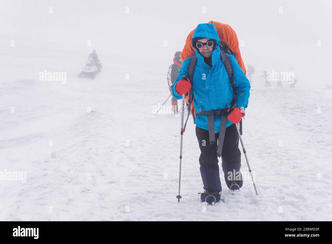 Elbrus, Russie - 31 juillet 2024 : les grimpeurs gravissent lentement la pente enneigée dans les nuages Banque D'Images
