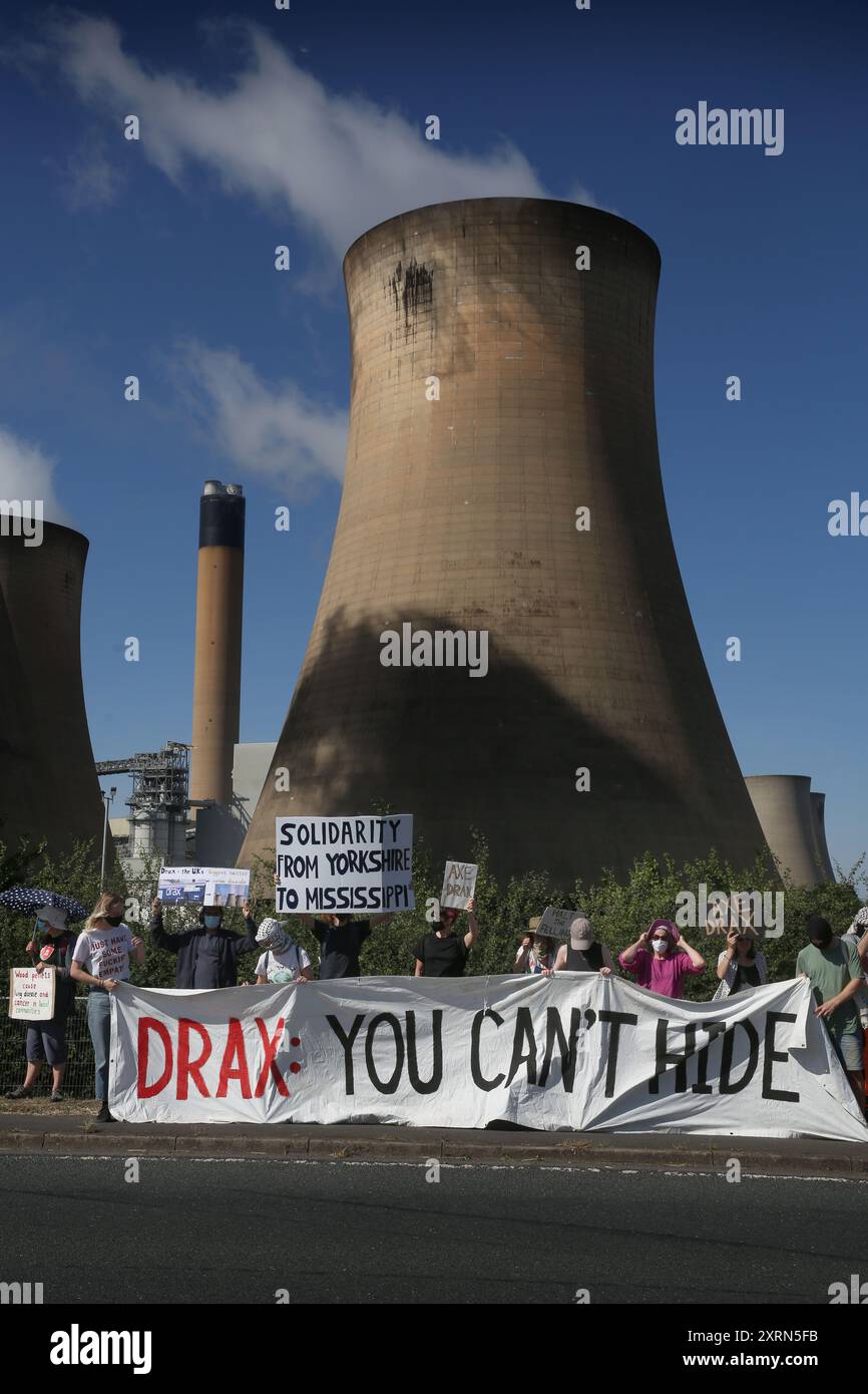 Selby, Angleterre, Royaume-Uni. 11 août 2024. Les manifestants se rassemblent le long de la route derrière une banderole disant˜Drax You't Hide' pendant la manifestation. Les manifestants affirment que les granulés de bois brûlés par la centrale électrique Drax nuisent aux forêts, à la faune et aux communautés du monde entier. Crédit : ZUMA Press, Inc/Alamy Live News Banque D'Images