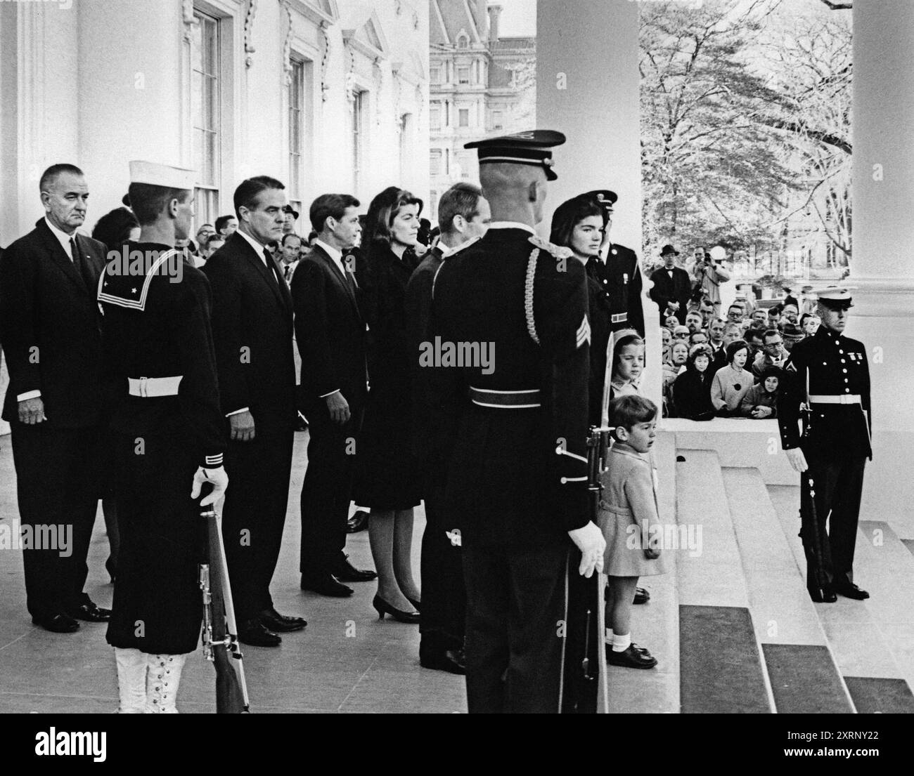 L'ancienne première dame des États-Unis Jacqueline Kennedy se tient avec ses enfants, Caroline Kennedy et John F. Kennedy, Jr., dans le Portique Nord, avant le cortège funèbre du président John Kennedy, debout derrière MRS Kennedy : Procureur général, Robert Kennedy; Patricia Kennedy Lawford, R. Sargent Shriver, président des États-Unis Lyndon Johnson, membres de la garde d'honneur debout à l'attention ; les personnes en deuil et les membres de la presse observent, Maison Blanche, Washington, D.C., États-Unis, Abbie Rowe, photographies de la Maison Blanche, 24 novembre 1963 Banque D'Images