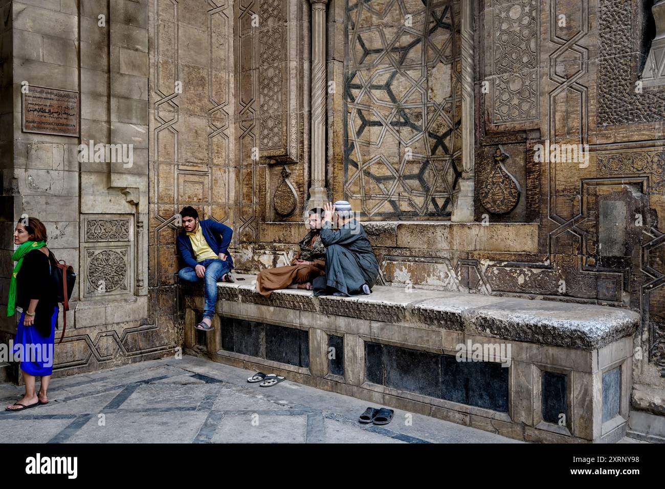 Gardiens assis devant le portail d'entrée de la mosquée du Sultan Hasan au Caire Banque D'Images