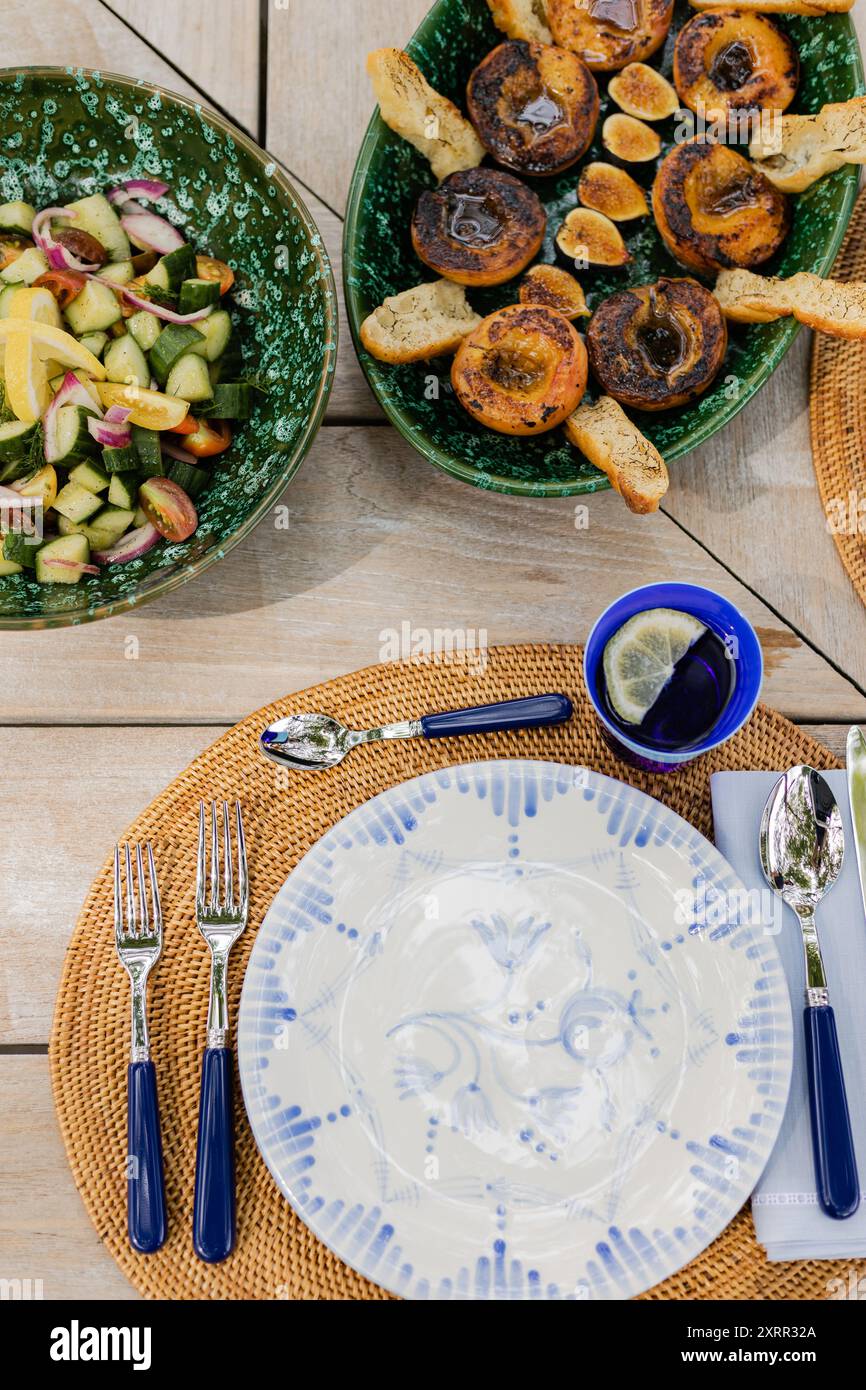 pêches et figues grillées, salade de concombre sur une table d'été en plein air Banque D'Images