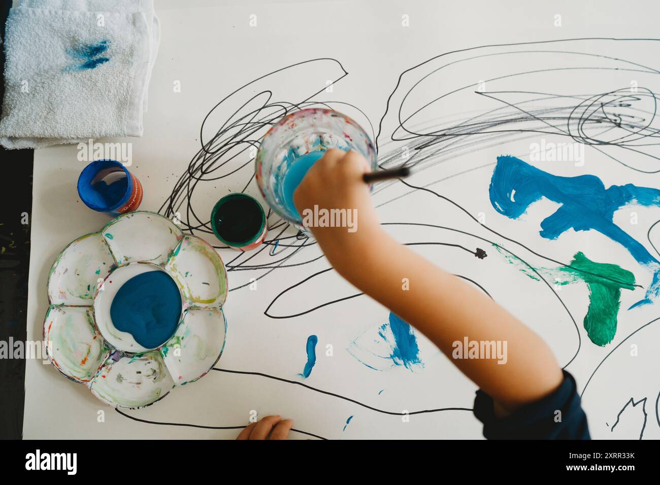 Vue de dessus de la peinture de main de jeune enfant avec des aquarelles Banque D'Images