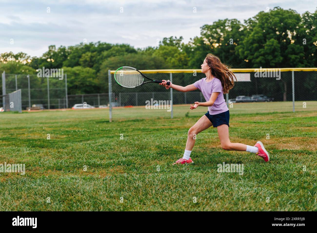 Une fille athlétique qui court balançait une raquette de tennis sur le terrain Banque D'Images