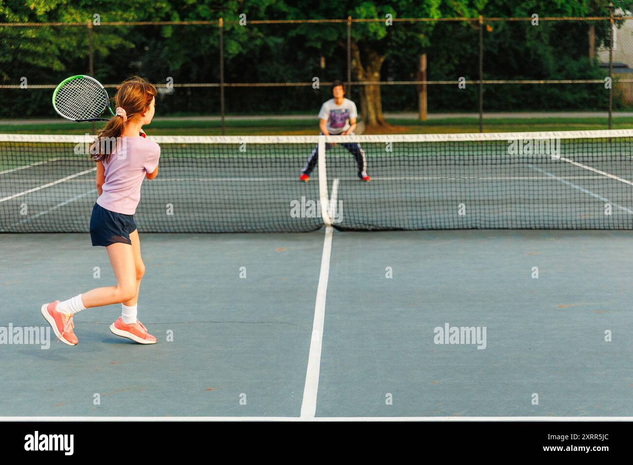 Une fille et un père jouent au tennis ensemble en été Banque D'Images