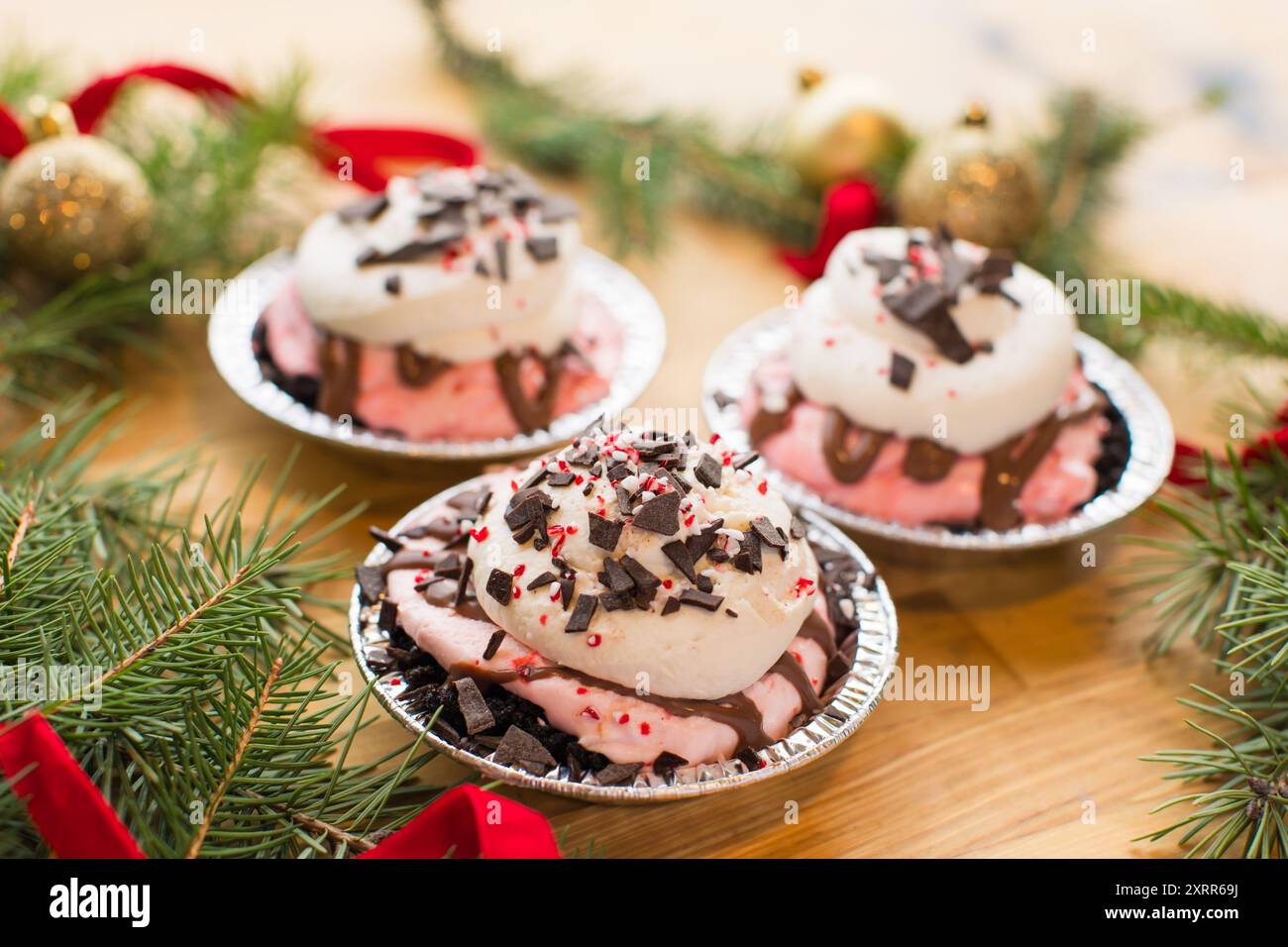 3 Mini tartes à la crème à la menthe poivrée recouvertes de morceaux de canne en bonbon et c Banque D'Images