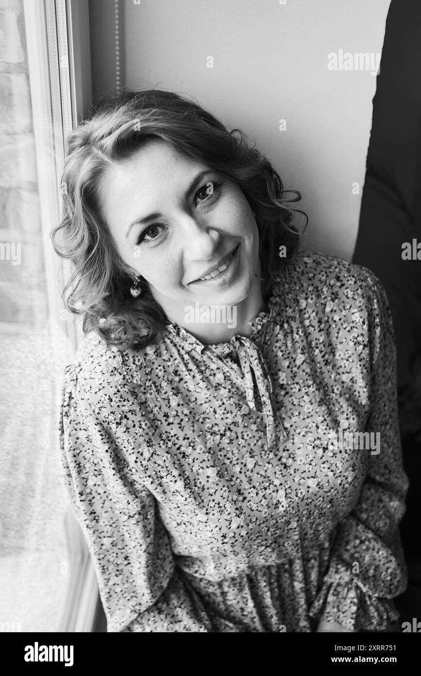 femme rêveuse d'âge moyen près de la fenêtre Banque D'Images